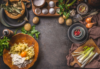 Obraz na płótnie Canvas Rustic food background with preparation of potato dough . Mashed potatoes with egg and flour in wooden bowl . Dark kitchen table with organic ingredients for tasty home cooking. Frame. Top view.