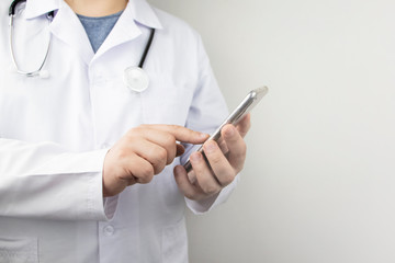 The doctor is holding a smartphone. Medical consultation by phone. Mobile app for healthcare providers