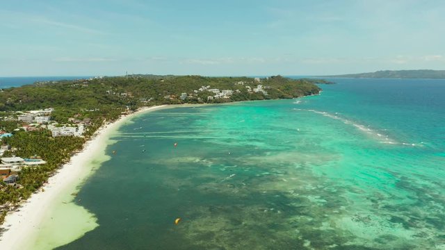 Tropical beach with turquoise water with kite-surfer rides, aerial view. Kitesurfing on a tropical island. Boracay, Philippines