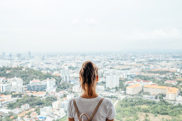 Fototapeta na wymiar Young caucasian woman looking at the city from the heights