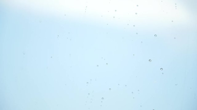 Drops of rain trickling down on black background isolated. Droplets of water on black glass background running down. 4K Stock Footage shot on high speed camera.