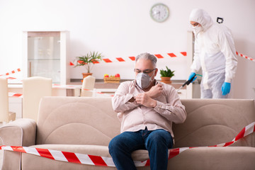 Young male sanitizer and old man indoors