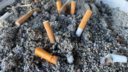 Cigarette butts and smoke in ashtray. anti-smoke. no smoking.