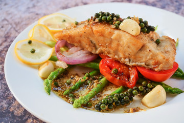 Grilled sea bass fish meat steak with vegetable and lemon