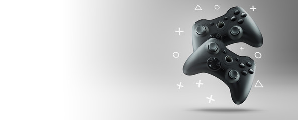 The concept of video games. Two gamepads levitate on a light background. Wide banner. - obrazy, fototapety, plakaty