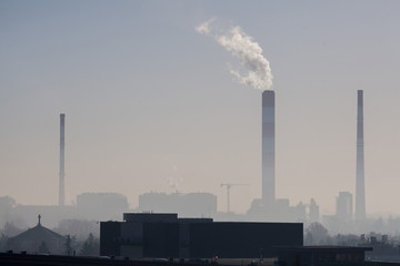 Dirty air or smog on the backdrop of an industrial city with factories, houses and churches or smoke that erupts from the pipe