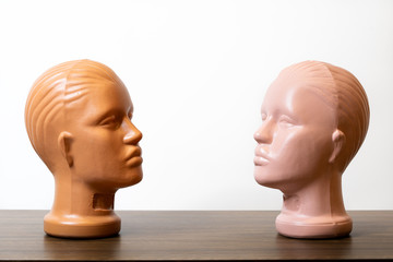 Two Mannequin Heads face to each other on wooden table
