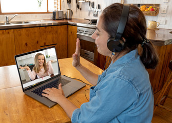 Teacher with laptop working from home online teaching student in live video class. Covid-19 lockdown