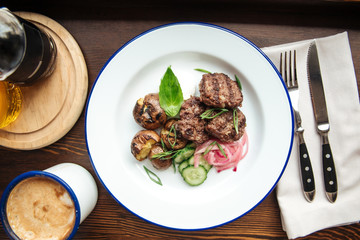 Top view on small grilled cutlets and mushrooms