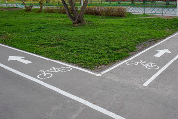 Two intersecting bike paths in the Park. Bike path sign on asphalt