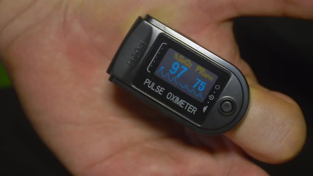 Pulse oximeter testing O2 saturation at 97% on patient index finger