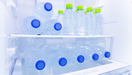 many mineral fresh drinking water in plastic bottle freeze in cooler shelf or refrigerator for cool water for person who want to refresh there life after business work or thirst and after meal food