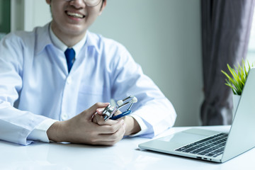 Fototapeta premium Asian doctor man wearing stethoscope white coat in his office hospital building.