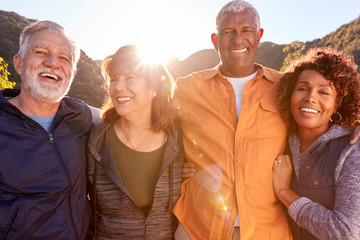 Portrait Of Smiling Senior Friends Walking In Countryside Together