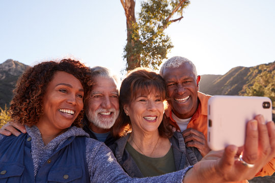 Group Of Senior Friends Posing For Selfie As They Hike Along Trail In Countryside Together