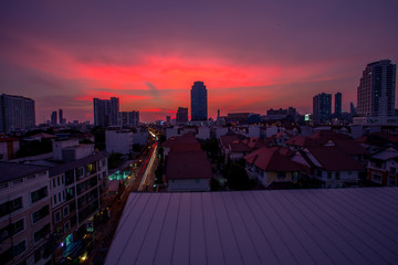 Fototapeta premium The high angle background of the city view with the secret light of the evening, blurring of night lights, showing the distribution of condominiums, dense homes in the capital community