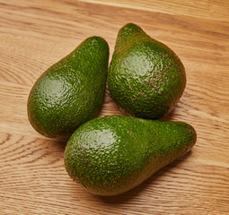 green avocado on a wooden table