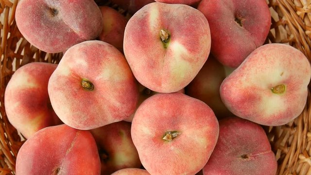 Flat peaches in the basket.