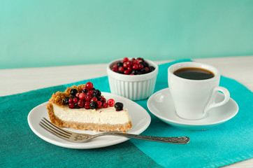 New York style Cheesecake on white plate decorated with fresh berries, on table with copy space so sweet and delicious. Homemade bakery concept.