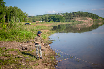 a boy pulls a rope from a river