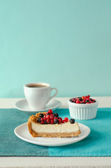 New York style Cheesecake on white plate decorated with fresh berries, on table with copy space so sweet and delicious. Homemade bakery concept.
