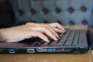 Female office worker typing on the keyboard.Woman using laptop in cafe close up.Young business woman working on her laptop.