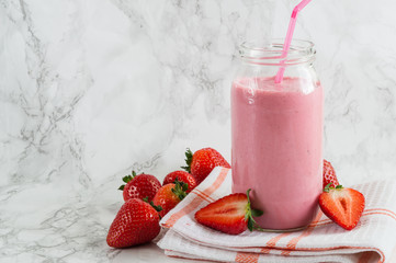 Strawberry milkshake in the glass jar on the table.