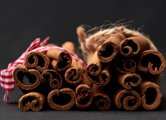 tied bunch of brown cinnamon sticks on a dark background