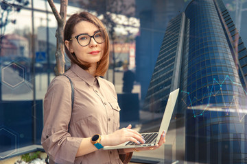 Fototapeta premium Business woman with computer on the background of a modern building.