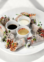 asian fresh vegetable vegan spring rolls with sauces in vietnam.