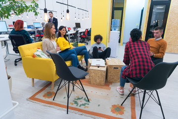 Multiracial young creative people in modern office. Group of young business people are working together with laptop, tablet, smart phone, notebook. Successful hipster team in coworking. Freelancers.