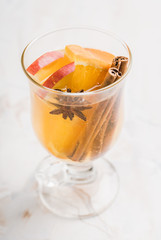 Healthy hot beverage with oranges, apples and spices for protection in flu season. Selective focus. Shallow depth of field.