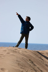 young boy posing on the sand dune on the beach of gulf of Finland baltic sea