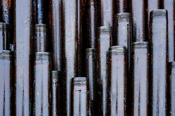 Obraz premium Texture oil drill pipe. Rusty drill pipes were drilled in the well section. Downhole drilling rig. View of the shell of drill pipes laid in courtyard of the oil and gas warehouse