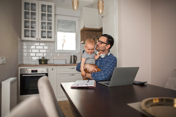 Fototapeta premium Father takes a break from work to play with his baby boy.