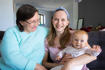 Grandma spending time with daughter and granddaughter. Mature and young woman with little child in home interior. Family generation concept