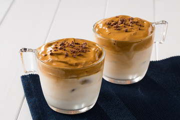 Whipped dalgona coffee with  copy space on a white wood background