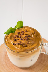 Whipped dalgona coffee with 
spearmint on a white wood background,   copy space
