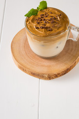 Whipped dalgona coffee with 
spearmint on a white wood background,   copy space