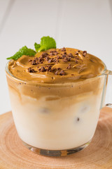 Whipped dalgona coffee with 
spearmint on a white wood background,   copy space