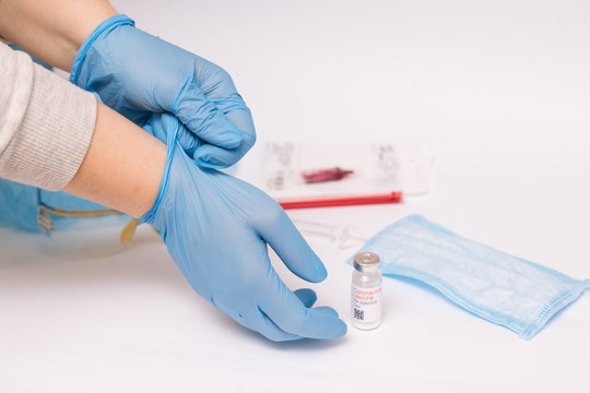 Coronavirus vaccine. Medical preparation in ampoule. Treatment for the disease, covid-19. The vaccine on a white background and on the background of a syringe, rubber gloves and goggles