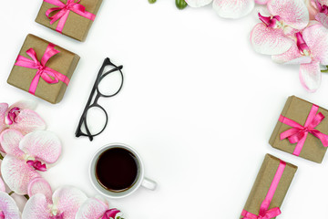 flatlay of Gift present boxes with pink ribbon and orchid flowers with eye glasses and coffee Gift concept. Copy space