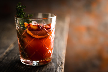 Old-fashioned cocktail with blood oranges and thyme on the rustic background. Selective focus. Shallow depth of field.
