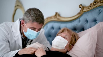 Doctor using stethoscope for auscultate caucasian elderly female patient with face mask at home. Life insurance, healthcare with long live, Coronavirus prevent epidemic