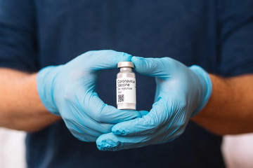 Coronavirus vaccine. Doctor with a vaccine. Hands holding a coronavirus vaccine ampoule, Covid-19