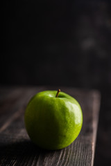 Close-up green apples on the rustic wooden background. Selective focus. Shallow depth of field.
