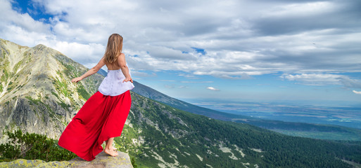 Young woman on the top of mountain