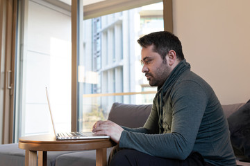 Fototapeta premium man working online at home or study using laptop on sofa. Stay home quarantine, Remote working
