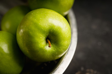 Close-up green apples on the rustic wooden background. Selective focus. Shallow depth of field.