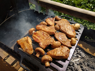 Grilled steaks with mushrooms and vegetables grilled near the house